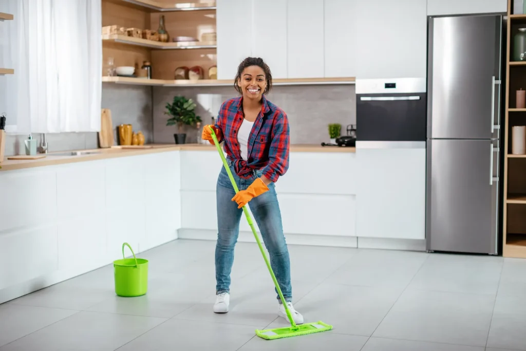 Domestic cleaning Adelaide: cleaner mopping a modern kitchen floor with a green mop and bucket